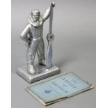 A large silvered-metal novelty desk-lighter in the form of a WWII British pilot holding a