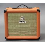 An orange “Crush 15” guitar amplifier.