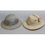 A mid-20th century West African polo hat; & a WWII steel safety helmet.