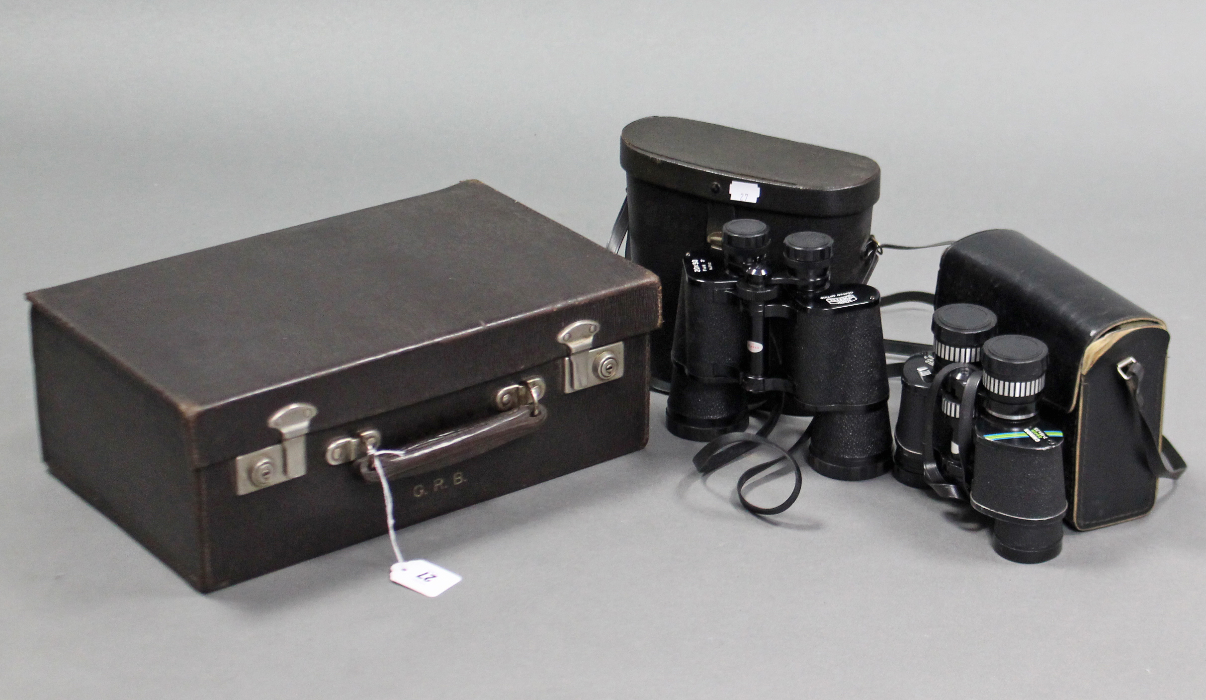 A brown morocco leather small travelling case, 15½” wide; & two pairs of binoculars; each with