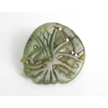 A Chinese carved & pierced jade roundel in the form of a fish amongst fronds; 2” wide.
