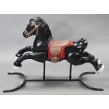 A mid/late 20th century black painted tinplate child’s rocking horse, 30” long x 37½” high.