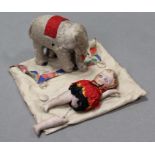 A clockwork-operated & cloth-covered automatic elephant, 3½” high; & a small china girl doll (w.a.