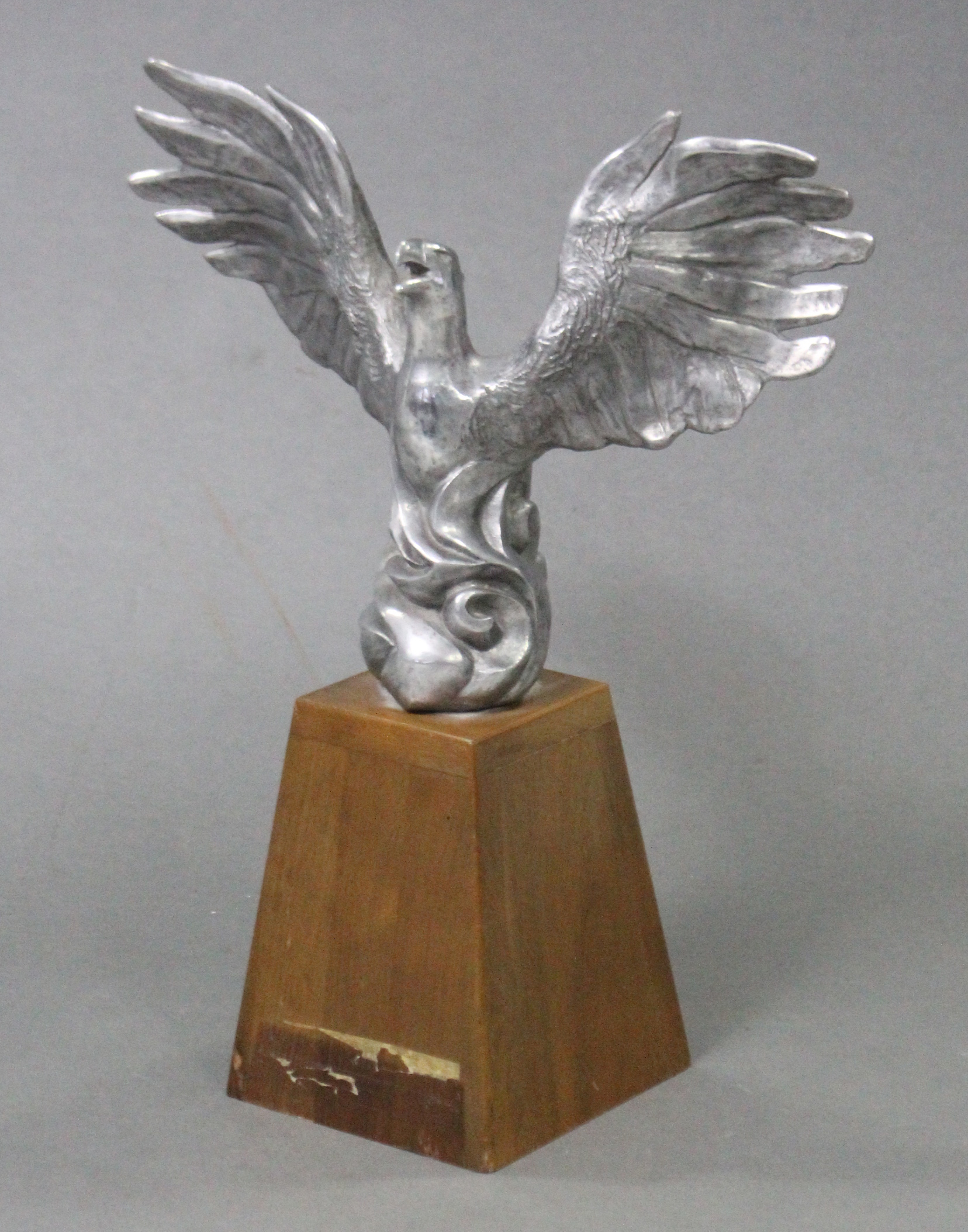 A cast alluminium model of a Phoenix, with wings spread, on tapered oblong wooden base, 17" high ove