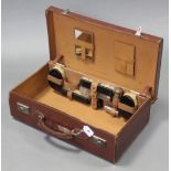 A mid-20th century tan leather travelling case with part fitted interior, 22” wide.