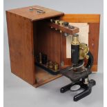 An early 20th century black lacquered monocular microscope with brass fittings by Charles Perry of