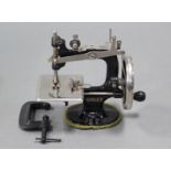 A vintage Singer child’s sewing machine, 5¾” wide, complete with clamp.