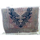 A Persian rug with floral and other designs, on a pink,
