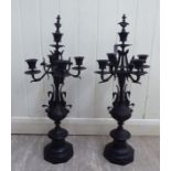 A pair of early 20thC cast and patinated bronze candelabra,