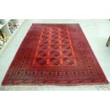 An Afghan carpet with canted, square designs and border ornament,