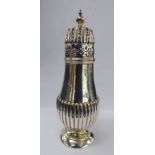 A late Victorian silver caster of demi-reeded baluster form with a decoratively pierced,