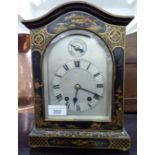 An early 20thC black lacquered and chinoiserie decorated oak cased mantel clock with an arched top