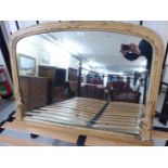 An early rustically constructed pine overmantel mirror with a shaped plate,