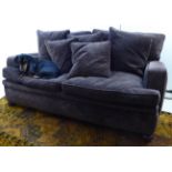 A two person settee, the cushioned aubergine coloured fabric upholstered seat raised on turned,