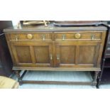 A 1920s oak sideboard with two frieze drawers, over two panelled doors,