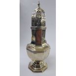 A silver caster of octagonal pedestal vase design with a decoratively pierced domed cover and