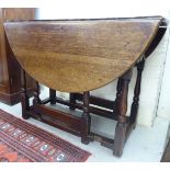 A late 18thC provincial oak gateleg table, the oval top with an end drawer and shaped apron,