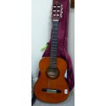 A child's Valencia Casa de Guitarras six string accoustic guitar with a maroon fabric carrying case
