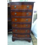 A modern reproduction of a Georgian mahogany finished serpentine front six drawer pedestal chest,