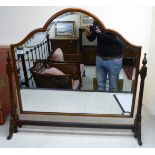 A 1930s dressing table mirror, the arched, bevelled plate set in a cushion moulded mahogany frame,