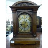 An early 20thC carved walnut cased mantel clock with an arched top and straight sides,