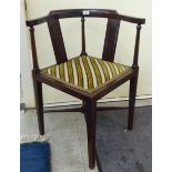 An Edwardian mahogany framed corner chair, the fabric upholstered seat raised on square,