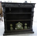 A late Victorian stained and profusely carved oak open front bookcase,