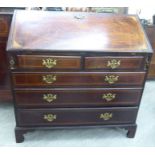 An early 19thC ebony and string inlaid mahogany bureau, the fall-flap enclosing a fitted,