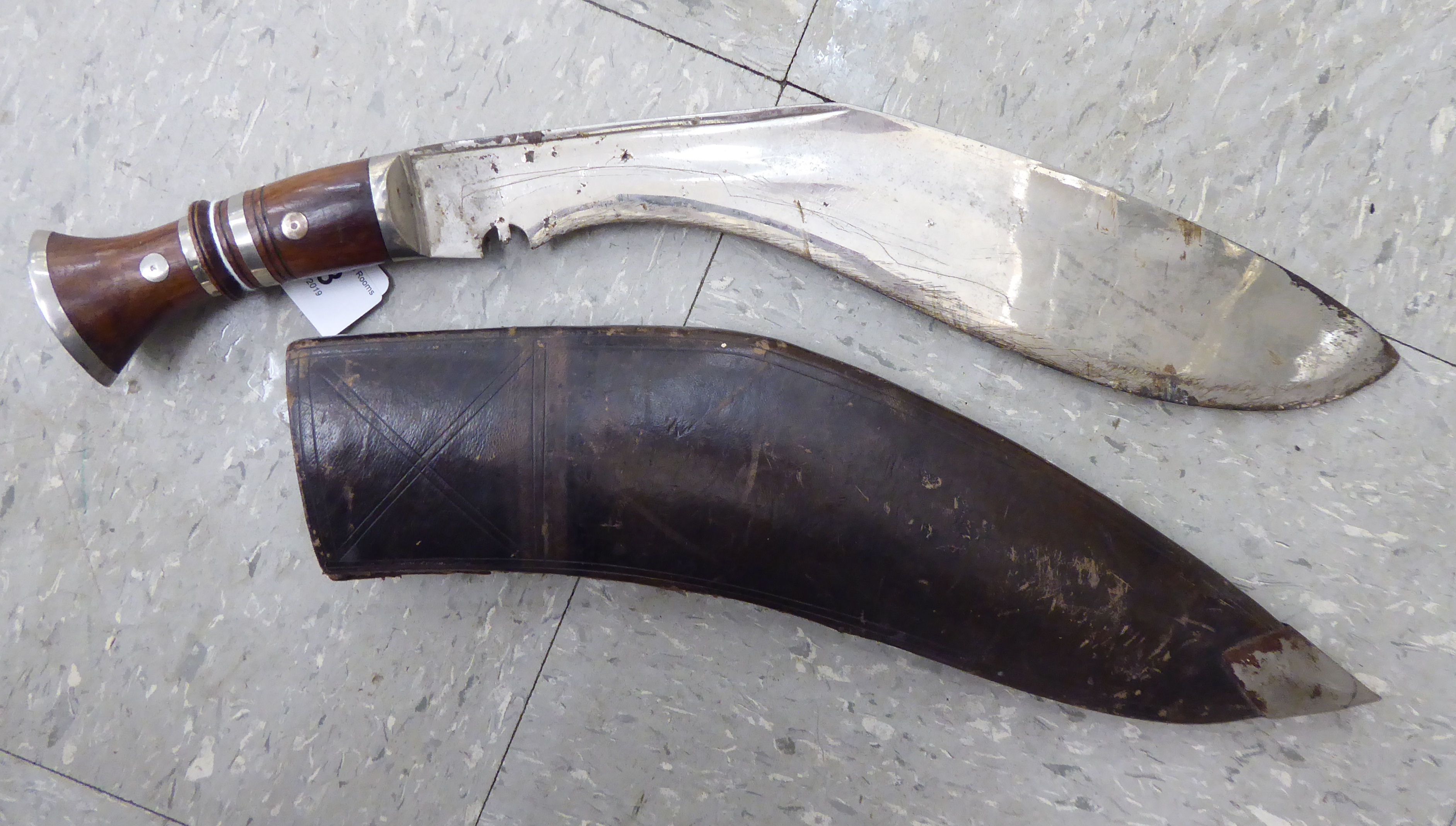 An early 20thC kukri with a hardwood handle, the blade 12''L in a moulded,