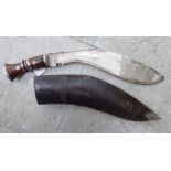 An early 20thC kukri with a hardwood handle, the blade 12''L in a moulded,