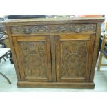 A late Victorian profusely carved light oak sideboard with lion mask handles,