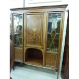 An Edwardian satinwood inlaid mahogany display cabinet with a central marquetry door,