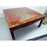 A modern lacquered red coffee table, raised on moulded, square legs,