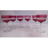 A set of six late Victorian clear and ruby coloured wine glasses with cup shaped, slice cut bowls,