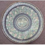 A 19thC Islamic stoneware charger, decorated with a continuous pattern of birds in foliage,