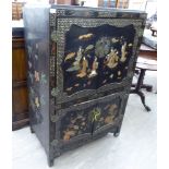 A mid 20thC Japanese black lacquered and gilded marriage cabinet with a pair of doors,