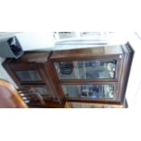 A late Victorian mahogany cabinet bookcase with a moulded cornice, over a pair of painted,