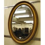 A late 19thC bevelled oval mirror,