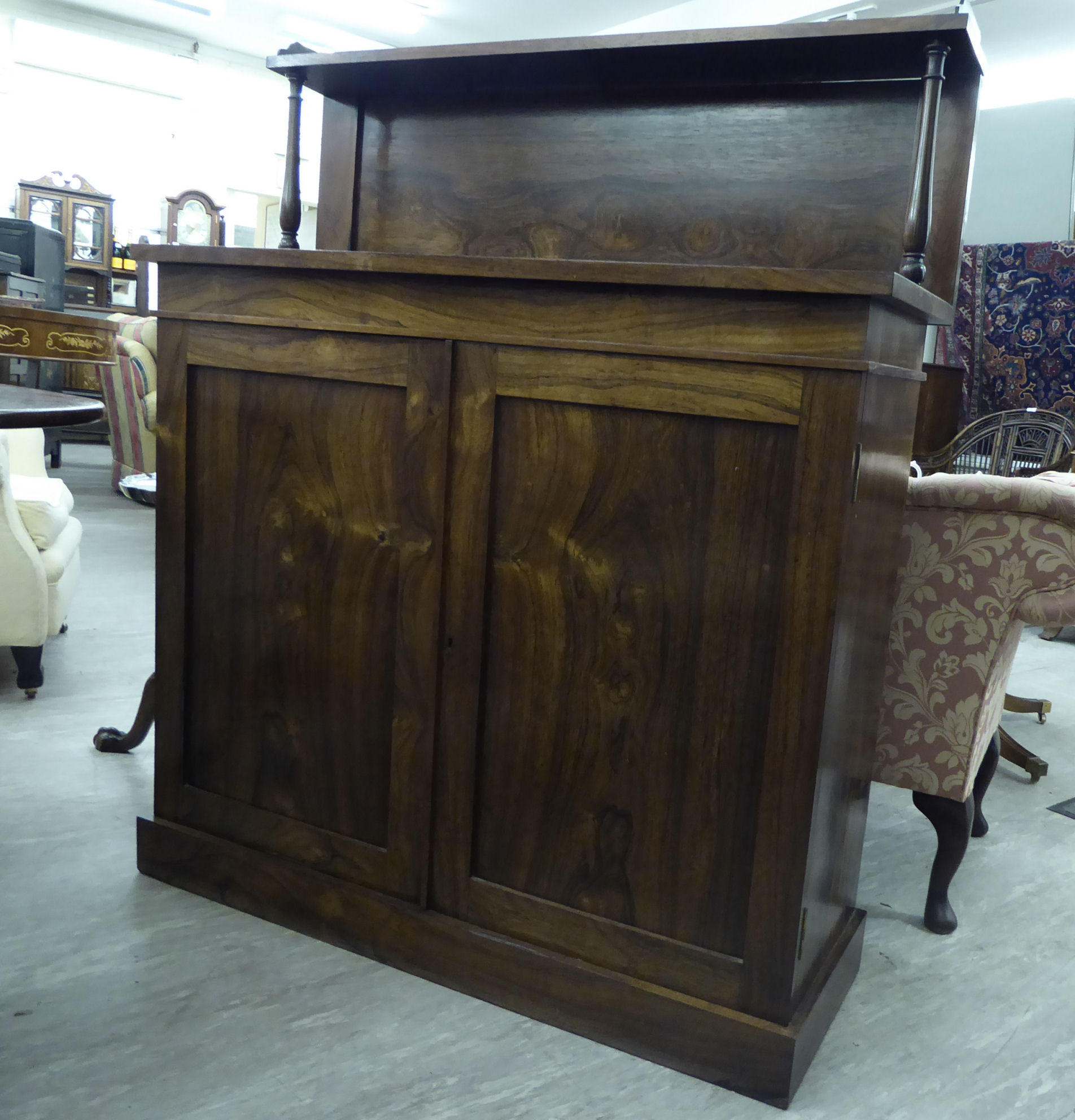 A mid Victorian rosewood chiffonier with a panelled upstand, over two panelled doors,