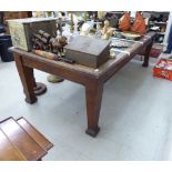 An early 20thC oak library table, the top set with an olive green fabric scriber,