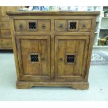 A modern Indonesian teak cabinet with two frieze drawers, over a pair of panelled doors,