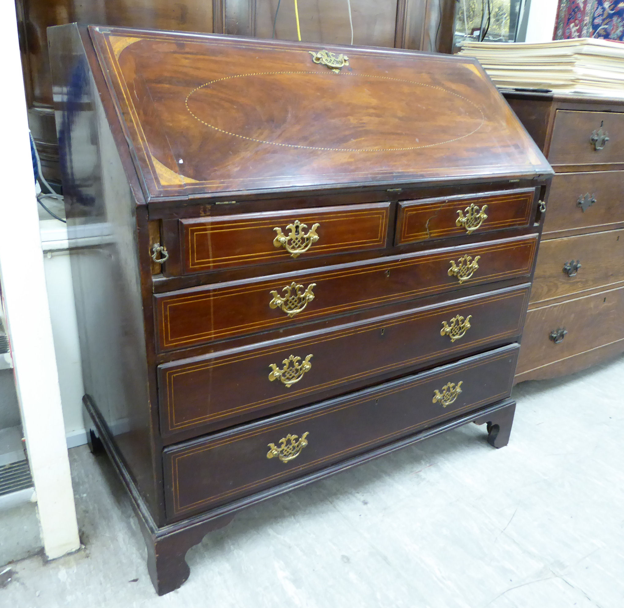 An early 19thC ebony and string inlaid mahogany bureau, the fall-flap enclosing a fitted interior,