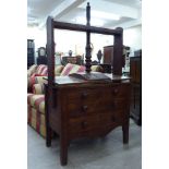 A George III mahogany linen press with a retractable planked shelf, over two short/two long drawers,