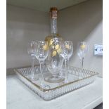 A late Victorian clear and gilded glass liqueur set comprising a decanter,