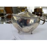 A silver coloured metal navette shaped sauce tureen with a cover and floral knop,