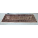 A Persian design runner with floral motifs on a peach ground 110'' x 37'' CA