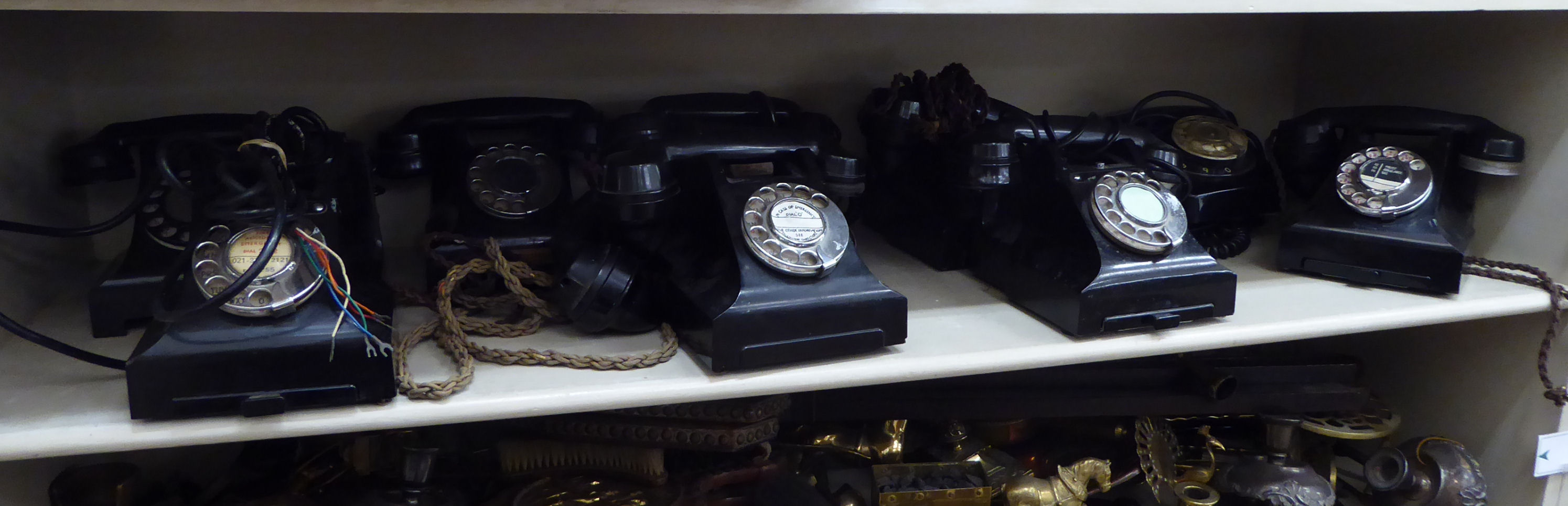 Nine 'vintage' black plastic cased cradle telephones with rotating dials OS8