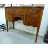 A modern yewwood bow front five drawer sideboard, raised on square,