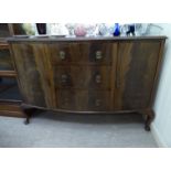 A 1920s mahogany bow front sideboard with three central drawers, flanked by a pair of doors,