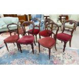 A set of four Edwardian walnut framed dining chairs with maroon fabric upholstered seats,